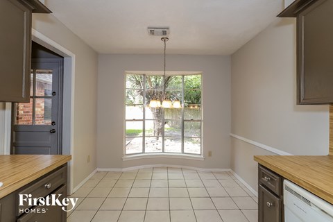 a kitchen with a large window and a white tile floor