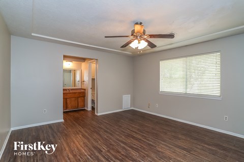 the living room of an empty house with a ceiling fan