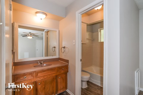 a bathroom with a mirror and a sink and a toilet