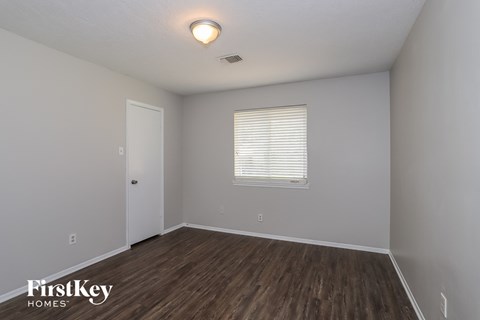 the interior of an empty room with wood flooring and a window