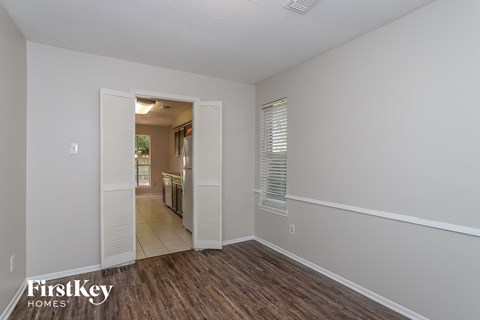 a living room with a hard wood floor and a door to a kitchen