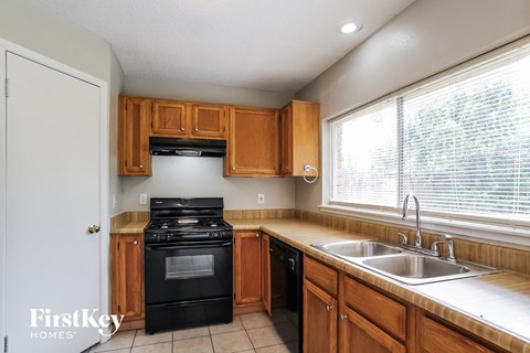 A kitchen with wooden cabinets and a black oven.
