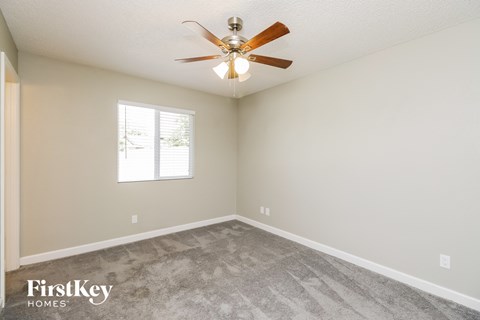 a bedroom with carpet and a ceiling fan