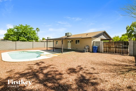a backyard with a pool and a house with a fence