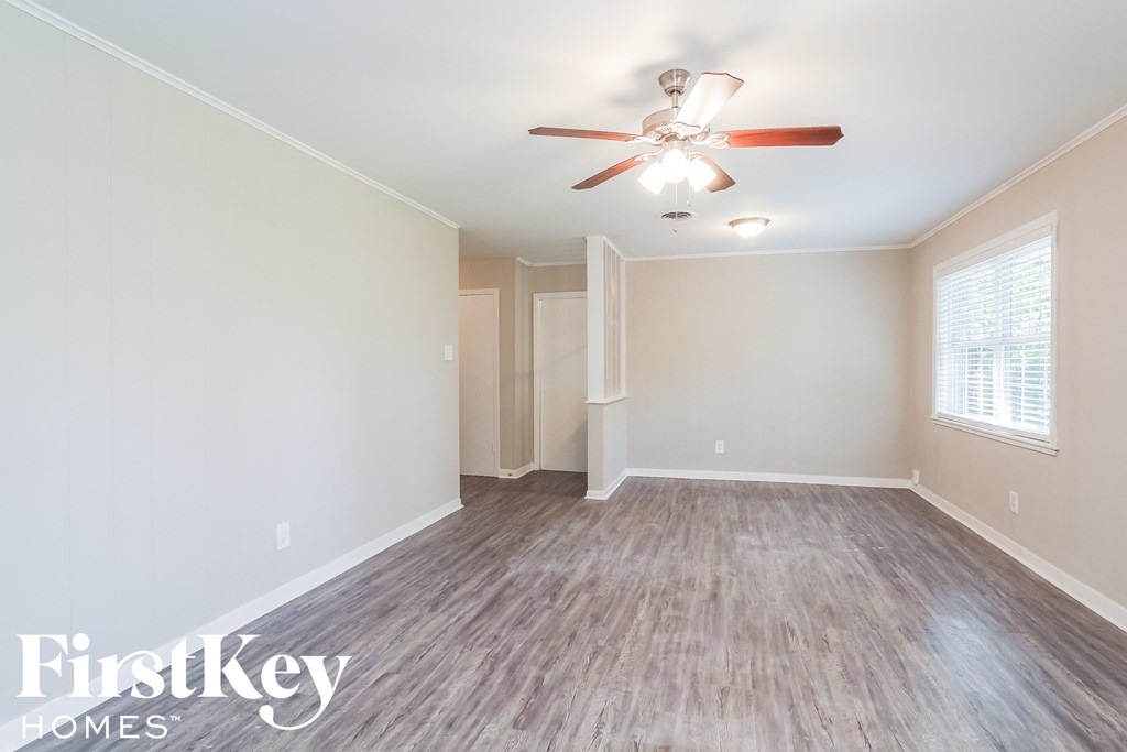 a living room with a ceiling fan and a wood floor
