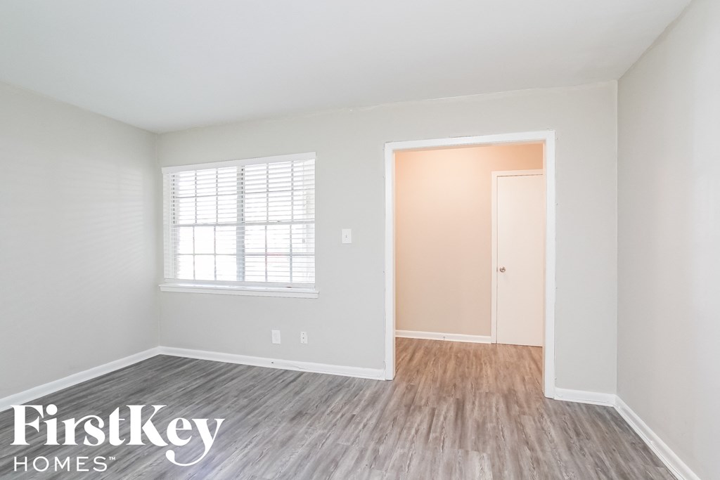 a white room with wood floors and a window