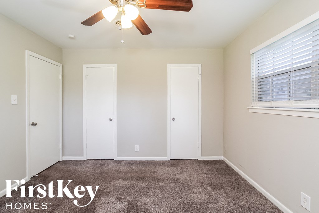 a bedroom with a carpeted floor and a ceiling fan