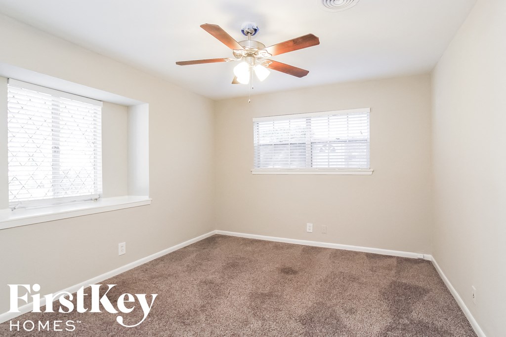 a bedroom with carpet and a ceiling fan