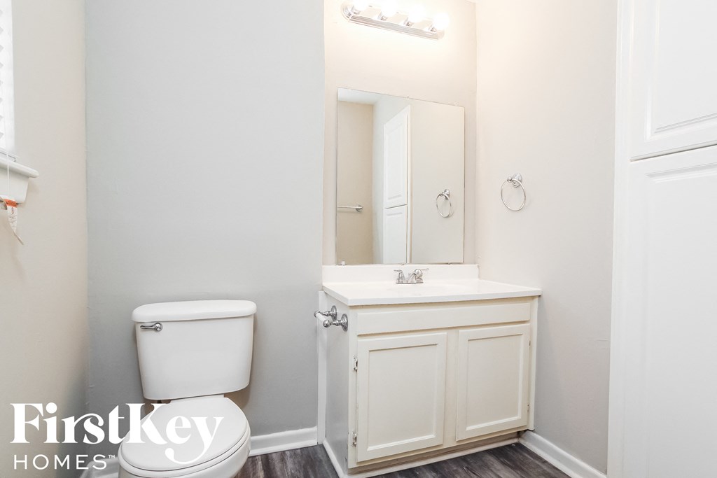 a white bathroom with a toilet and a sink