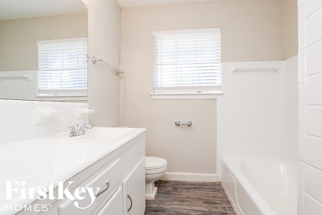 a white bathroom with a tub and a toilet and a sink