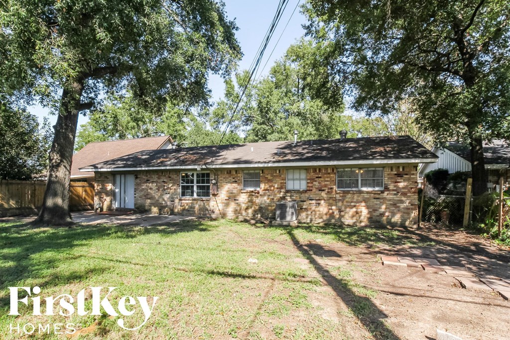 a small brick house with a yard and trees