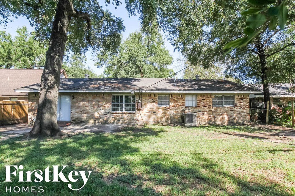 a small brick house with a yard and trees