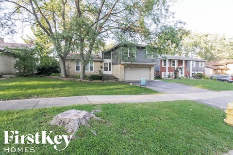 a home in a neighborhood with trees and a sidewalk
