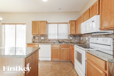A kitchen with wooden cabinets and a white stove top oven.