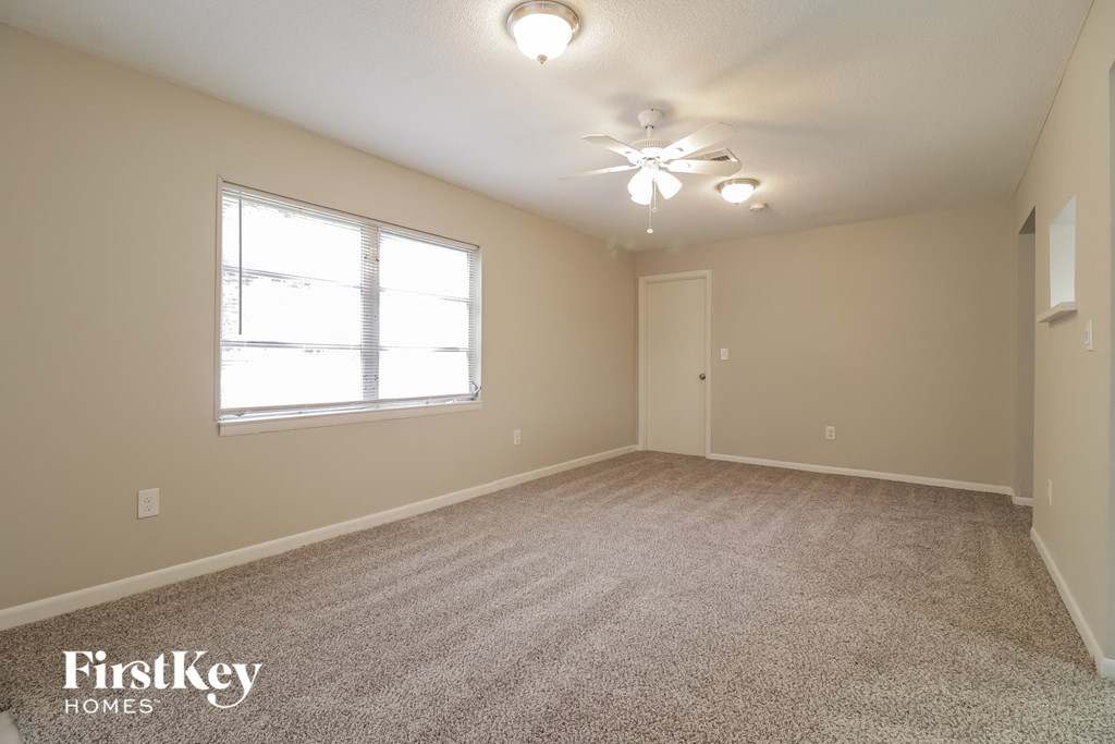 a spacious living room with carpet and a large window