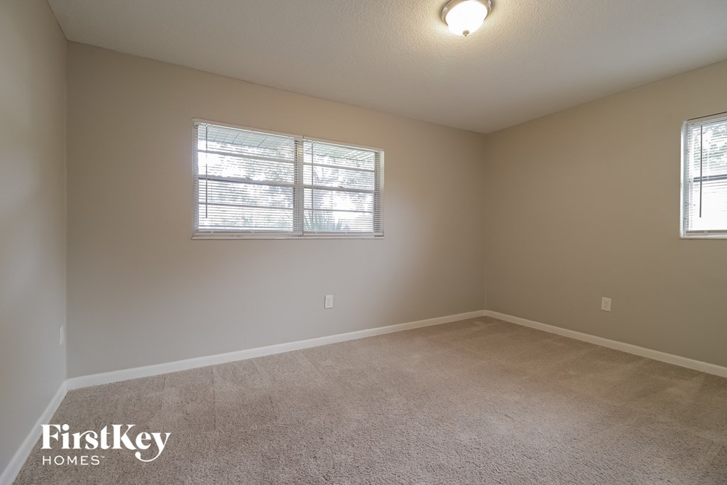 a bedroom with a carpeted floor and a window