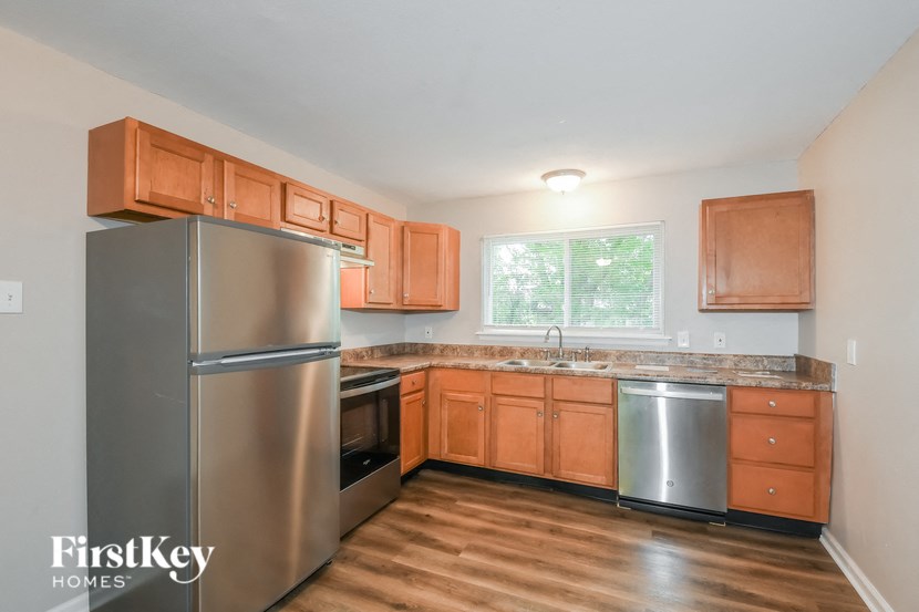 A kitchen with wooden cabinets and a stainless steel refrigerator.