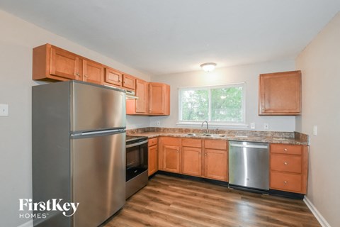 A kitchen with wooden cabinets and a stainless steel refrigerator.