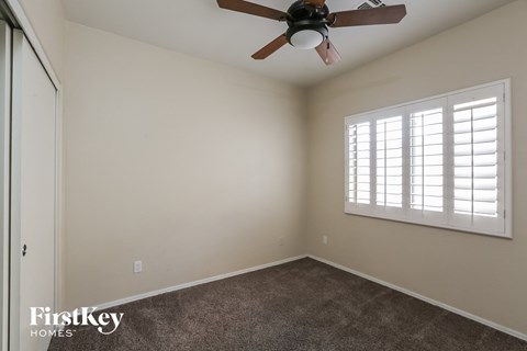 a bedroom with a ceiling fan and a window