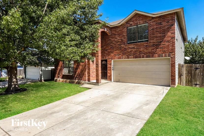 A brick house with a garage door is for sale.