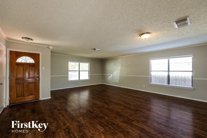 A room with wooden floors and a FirstKey Homes logo.