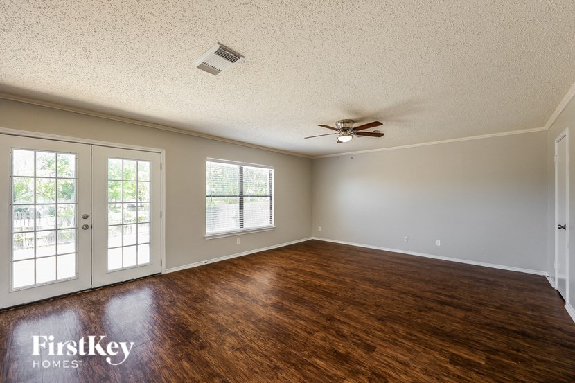 A room with wooden floors and a ceiling fan.