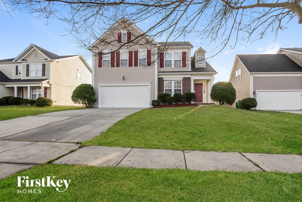 a house with a driveway and a lawn in front of it