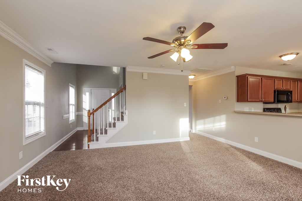 an empty kitchen and living room with a ceiling fan