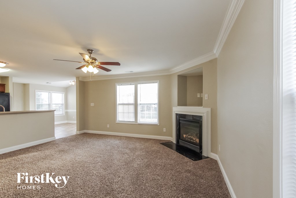 a living room with a fireplace and a ceiling fan