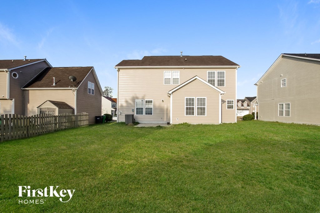 the backyard of a house with a yard and a fence