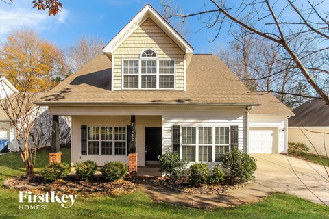 the front of a house with a porch and a driveway