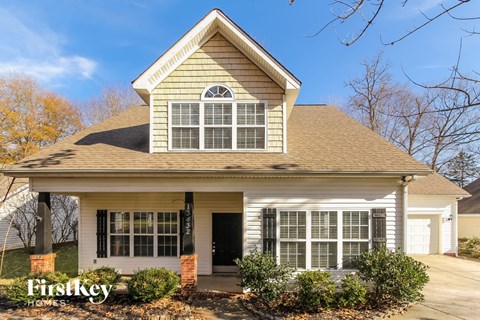 the front of a house with a front porch and a garage