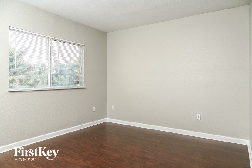 A room with a window and wooden floors.