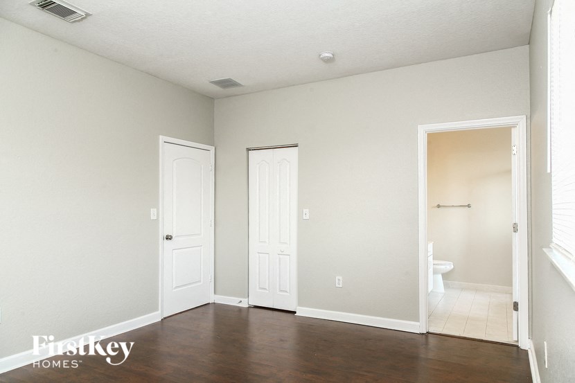 A room with a white door, a white wall, and a white ceiling.