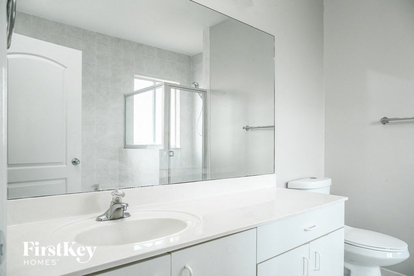 A bathroom with a sink, mirror and toilet.