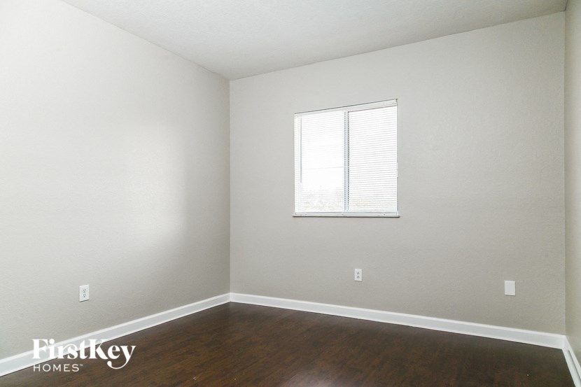 A room with a window and wooden floors.