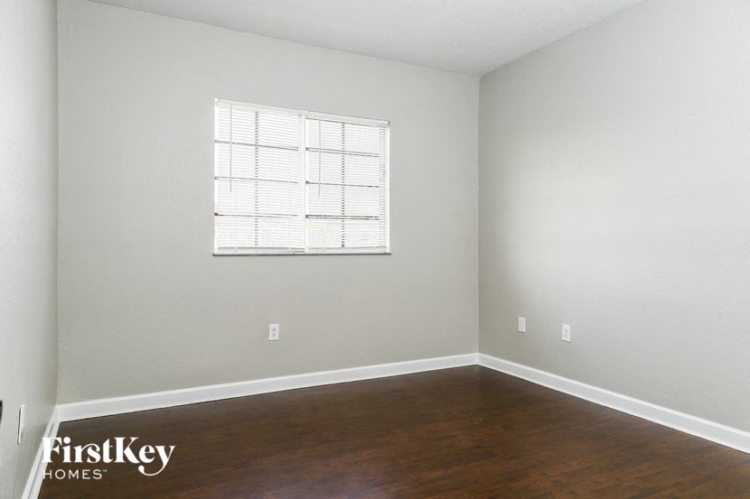 A room with a window and wooden floors.