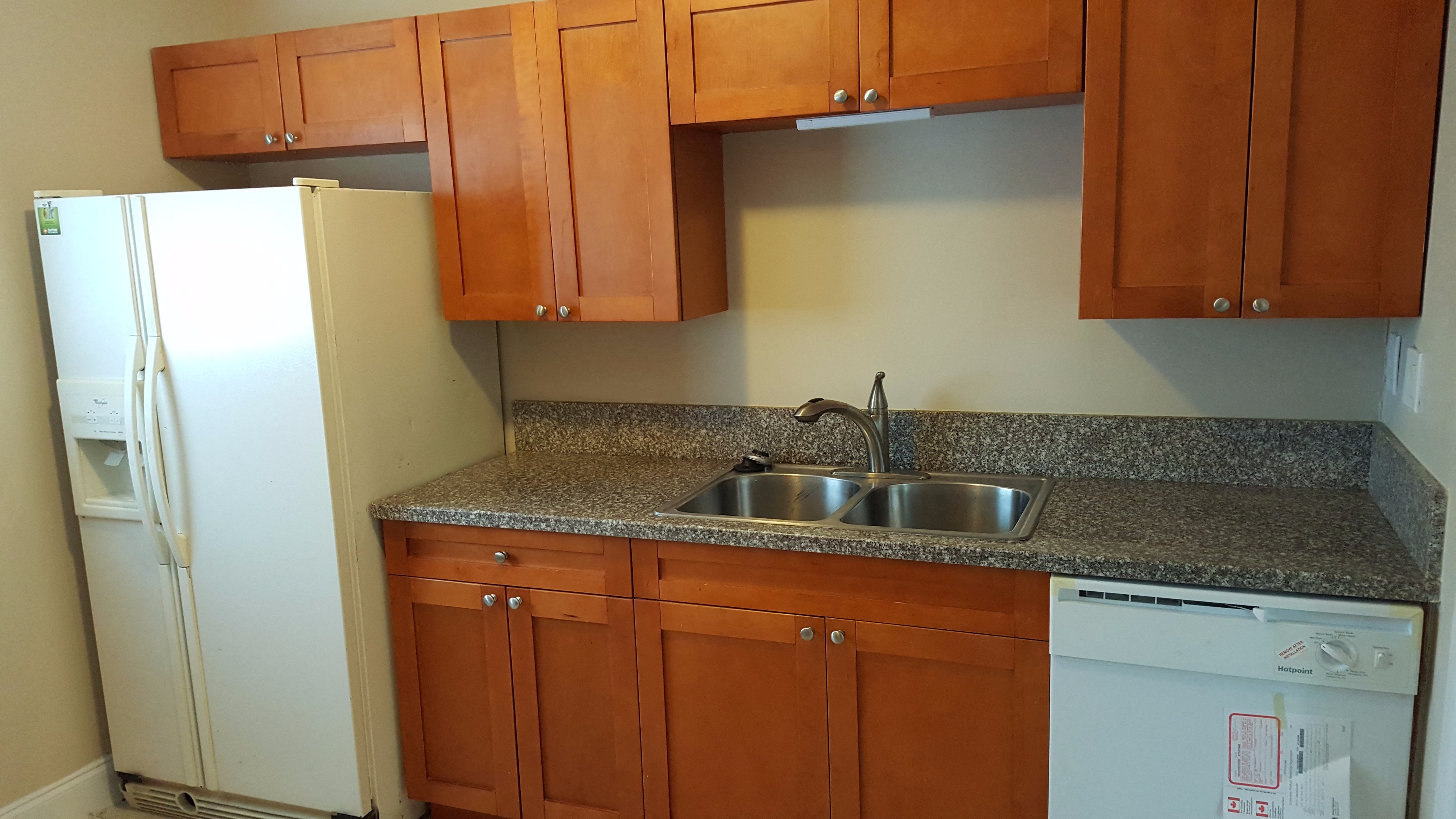 a kitchen with wooden cabinets and a sink and a refrigerator