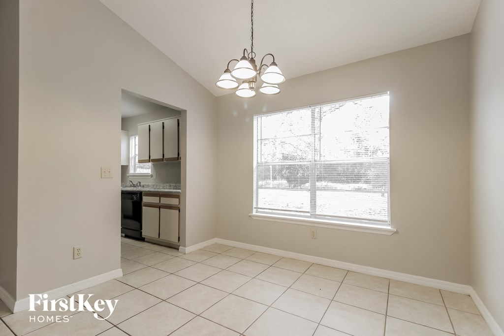 a kitchen with a large window and a tiled floor
