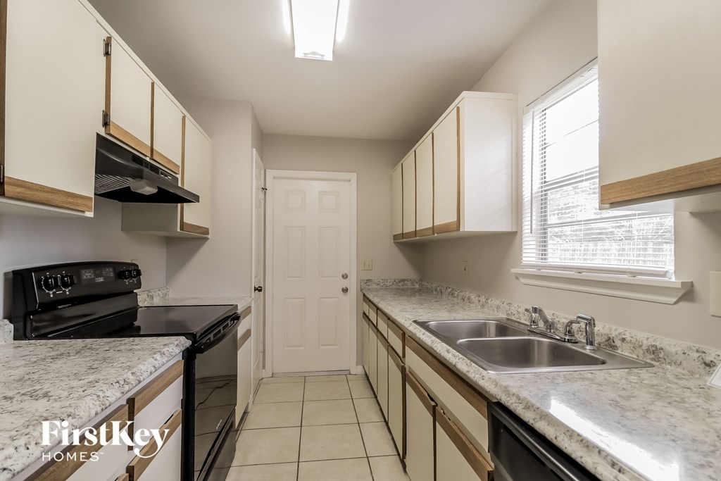 a kitchen with granite counter tops and black appliances and a sink