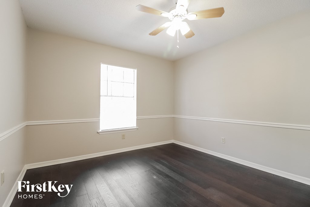 a bedroom with hardwood flooring and a ceiling fan
