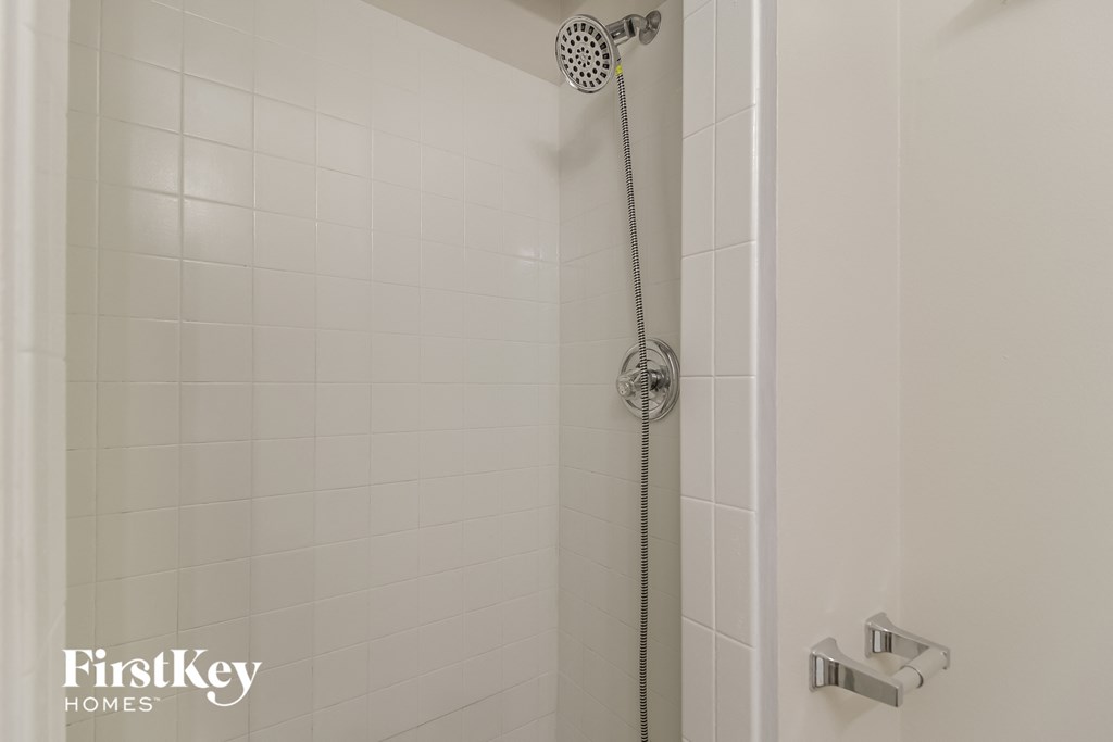 a white tiled shower in a white bathroom