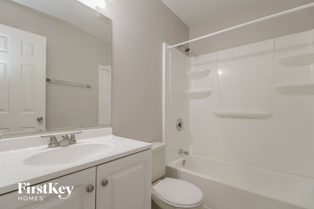 a bathroom with a sink toilet and shower and a mirror