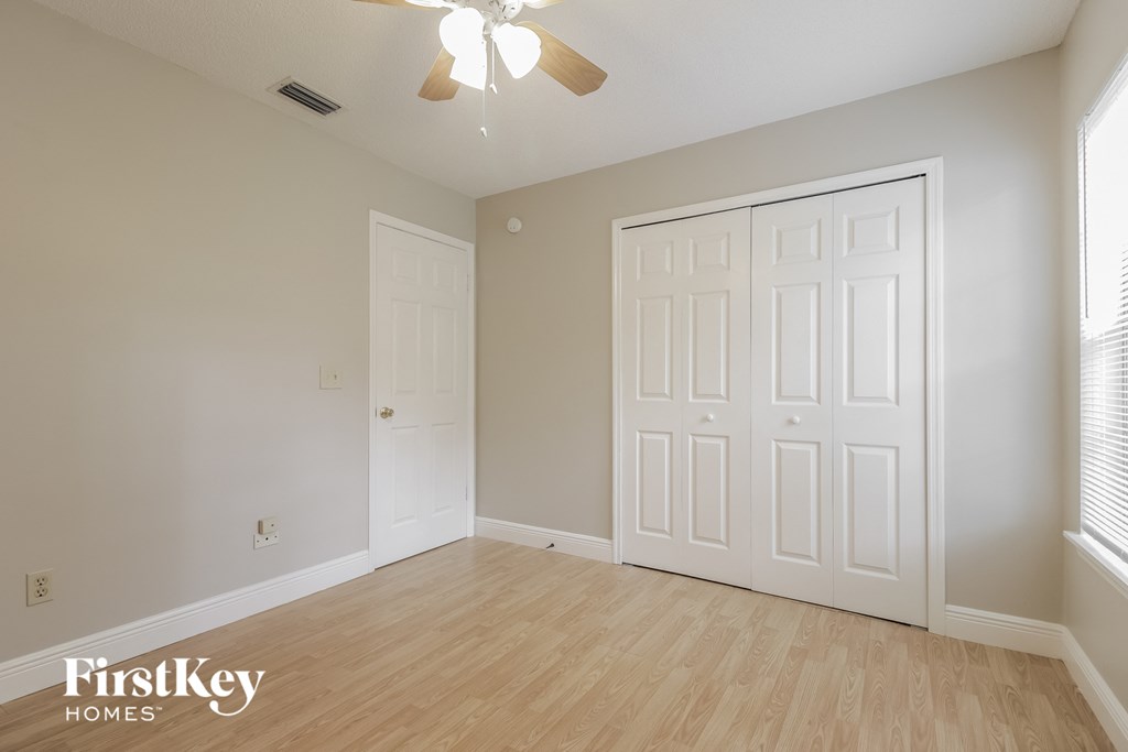 a bedroom with two closets and a ceiling fan