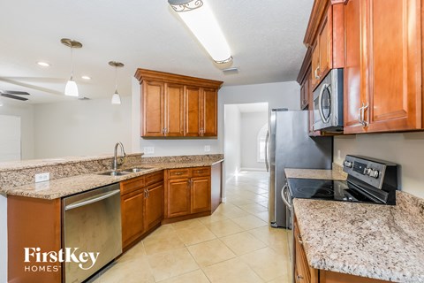 a kitchen with wooden cabinets and granite counter tops and stainless steel appliances