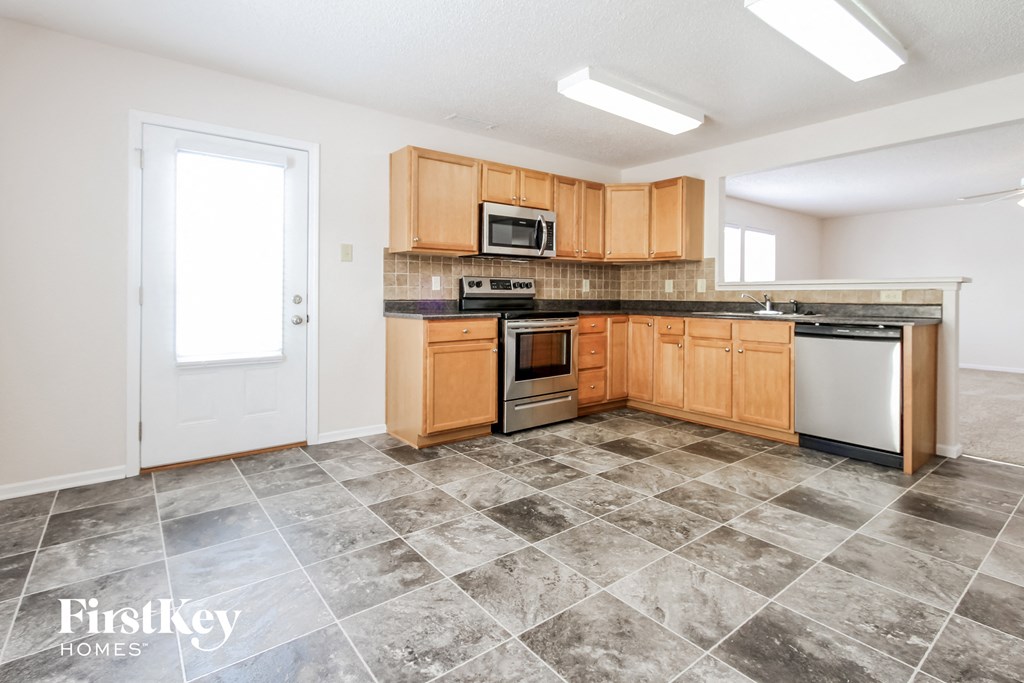 a kitchen with wooden cabinets and stainless steel appliances