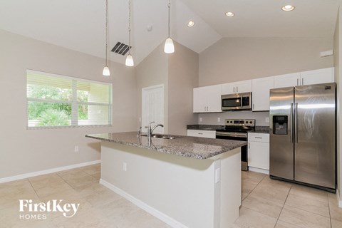 a large kitchen with stainless steel appliances and granite counter tops