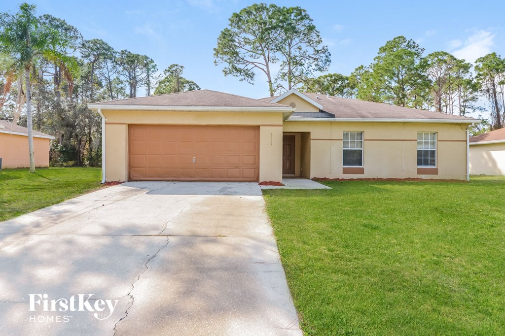a beige house with a driveway and a garage door