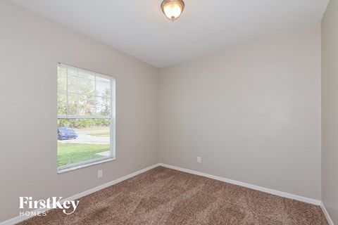 the living room of a home with carpet and a large window