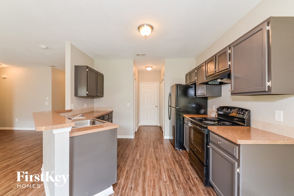 a kitchen with stainless steel appliances and a hard wood floor
